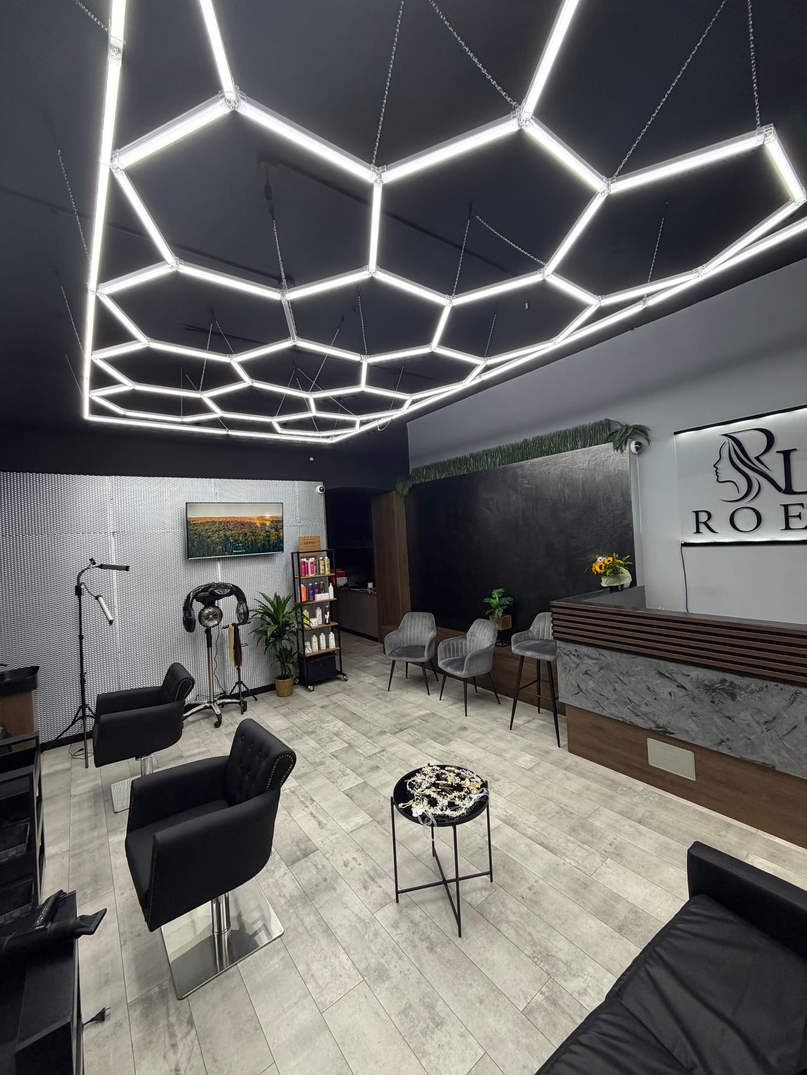 Recepcia a čakáreň salónu ROEL Beauty s logom na stene